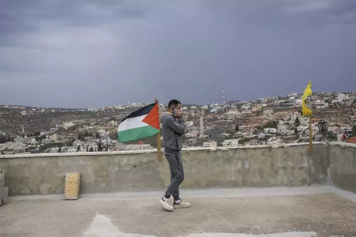Un proche de deux hommes tués par des colons israéliens lors d'un cortège funèbre le 12 octobre 2023, depuis le toit de sa maison, dans le village palestinien de Qusra, en Cisjordanie, le 12 novembre 2023. Image d'illustration. AP / Mahmoud Illean.